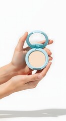 Elegant hands gently hold an open compact face powder, showcasing its smooth texture and stylish light blue case, a beauty essential for a flawless, radiant complexion