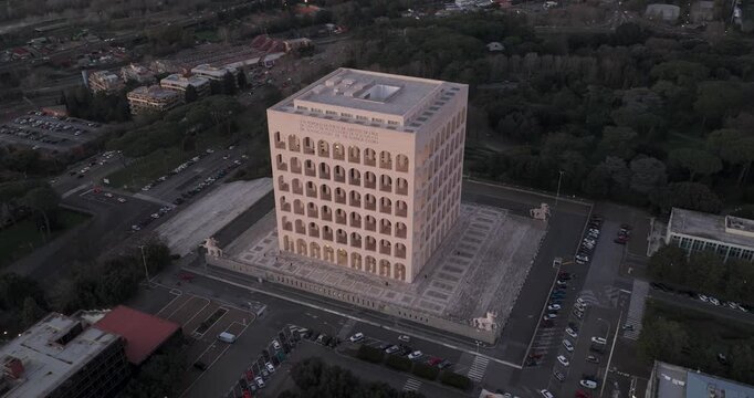 Aerial view of the Palazzo della Civilta Italiana, its stark geometric facade contrasting with the surrounding trees and urban landscape, Rome, Lazio, Italy.