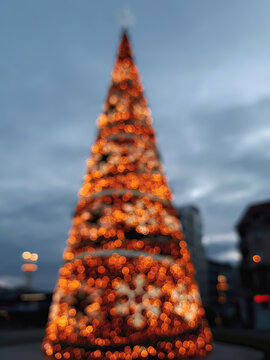 Blurry abstract background with glow Christmas tree in night town
