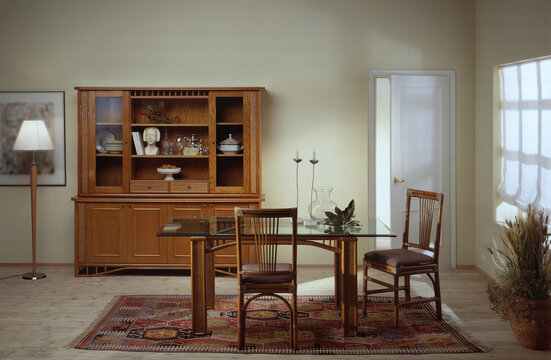 Single shot photo of a room with a rattan table, chairs and display cabinet