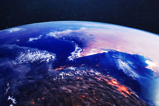 Cinematic satellite view of the Strait of Hormuz and Iran at night, showing glowing city lights and strategic coastlines. Concept of geopolitical tension, energy security, and regional conflict