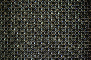 Full-frame abstract pattern of stacked glass bottle bases.