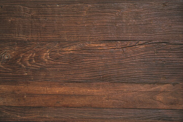 Naklejka premium Close-up of weathered dark brown wood grain texture with natural cracks.