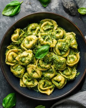 A delicious bowl of pesto pasta with fresh herbs on a table