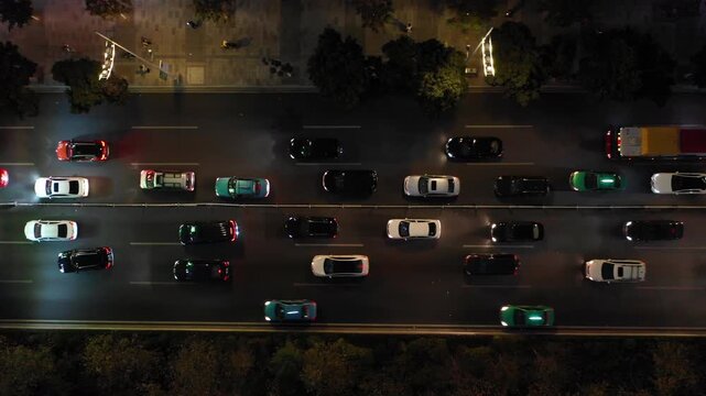 Panning drone shot of cars using headlights in evening commute rush hour in Guangzhou, China
