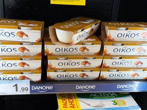 Mallorca, spain, february 20, 2026, oikos greek yogurt with caramel, from danone, displayed on a grocery store shelf, showing quantity, price, and branding