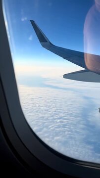 Flight Experience: Capturing the Serene Beauty of the Sky from an Airplane Window with Clouds and Aircraft Wing