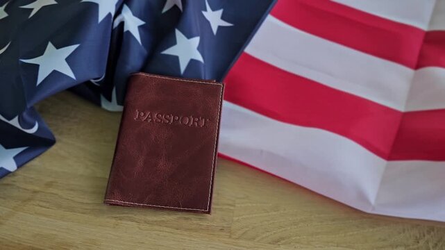 Passport and flags on a wooden table at a travel planning session in the United States
