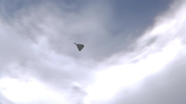 Small Shahed 136 Kamikaze Drone Passing Above with Blue Sky Cloud Background. Realistic 3d animation. UAV Unmanned Aerial Vehicle. Modern Technology Warfare in the Air. Combat Aircraft.