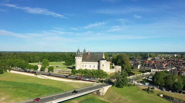 Scenic aerial view of the historic Sully sur Loire castle surrounded by greenery and the town under a clear blue sky in France.