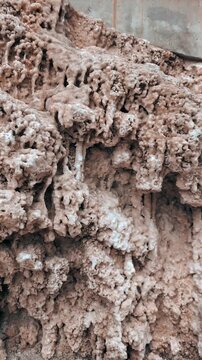 Natural mineral cave formations texture : Close up geological surface showing dripping calcite deposits and rough limestone structure formed over time in underground environment.