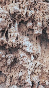 Natural mineral cave formations texture : Close up geological surface showing dripping calcite deposits and rough limestone structure formed over time in underground environment.