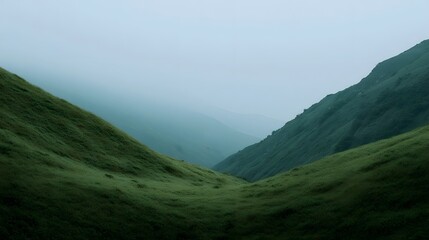 Serene mountain valley with rolling green hills under a misty overcast sky