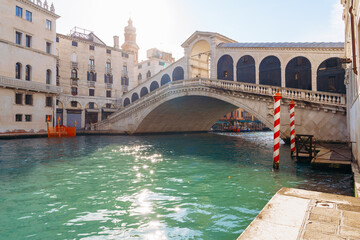 Rialto Bridge over water in Venice with buildings and clear sky in the background © fotofabrika