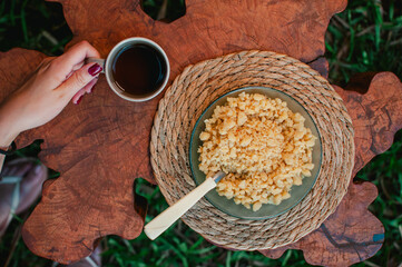 Taza de mate cocido con un plato de reviro sobre una mesa rústica, desayuno Argentino © Daniel