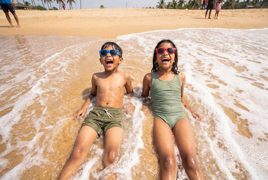 happy little indian brother and sister enjoying together at beach