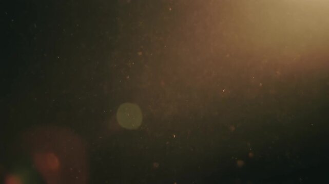 Floating dust particles with warm bokeh light.