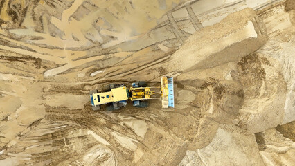 Loader tractor at the quarry aerial view from a drone. Construction work at the sand quarry. High quality photo © Антон Скрипачев
