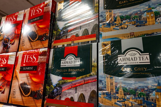 Various tea brands including Ahmad Tea and Tess displayed on store shelves in a market setting