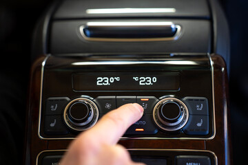 Passenger pressing airflow direction button of the climate control system on the rear control panel...