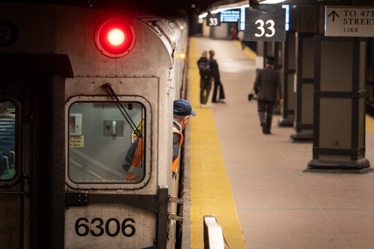 Sur un quai de gare un conducteur de train contr&ocirc;le le quai avec trois passager &agrave; New-York