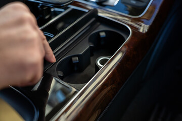 Open cup holder compartment in luxury car center console designed for beverage storage.