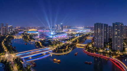 Naklejka premium Vibrant Guangzhou Night Skyline: Modern Stadiums and Illuminated River