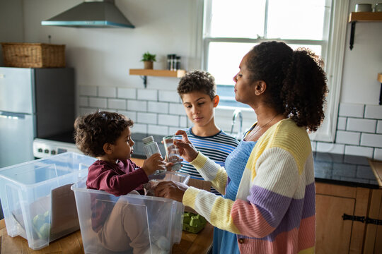 Mother and children sorting recycling in kitchen