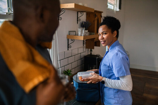 Healthcare worker packs lunch in home kitchen before work