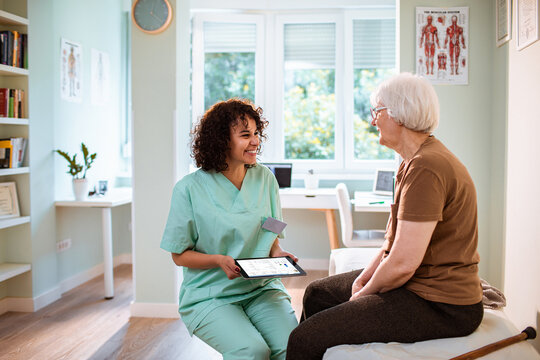 Smiling nurse consulting senior patient in medical office