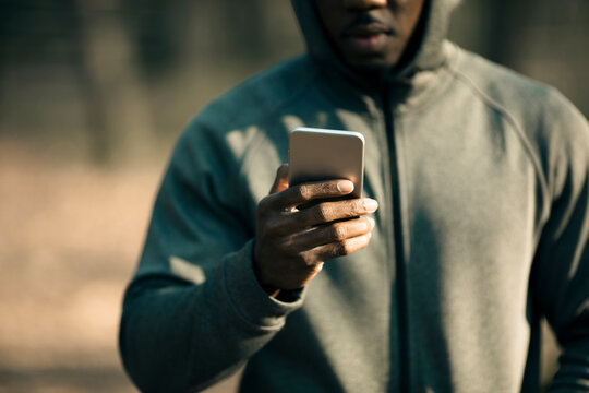 Athlete checking smartphone during outdoor workout