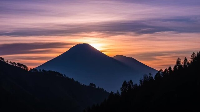 Sunset over mountain landscape with trees.