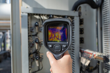 Thermal camera screen captures predictive maintenance inspection inside an electrical control cabinet, revealing heat anomalies to support safety, reliability, and fault diagnosis.