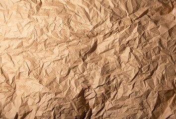 Wrinkled crumpled kraft brown paper texture, background in grunge style.