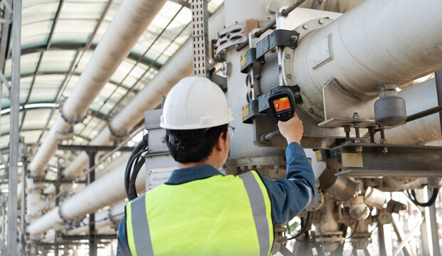 Engineer performs industrial monitoring with a thermal camera on high voltage gas insulated equipment, supporting heat inspection, safety, reliability, diagnostics, and maintenance.