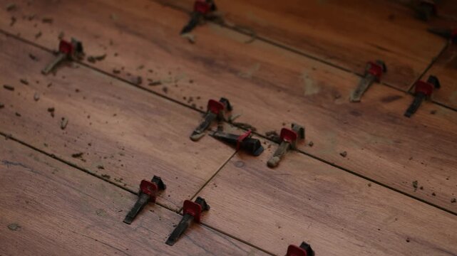 Instalation of ceramic tile on a floor. Floor leveling system. 4K