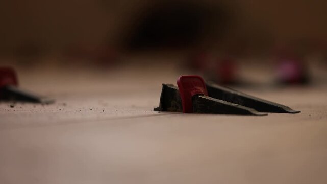 Instalation of ceramic tile on a floor. Floor leveling system. Closeup. 4K
