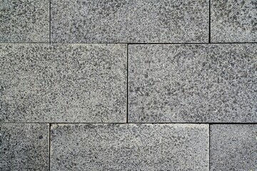 Obraz premium Grey textured rectangular stone wall background. Coarse granite texture. High-resolution grey granite stone tile texture background. Seamless basalt pavement blocks for architectural 3D rendering.