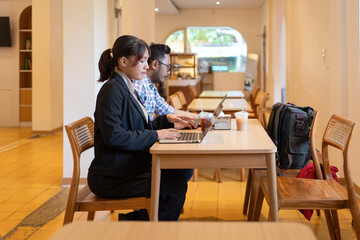 Business Colleagues Working on Laptop and Tablet at Cafe Workspace