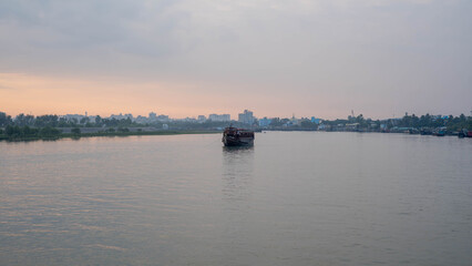 River boat floating near city at sunset