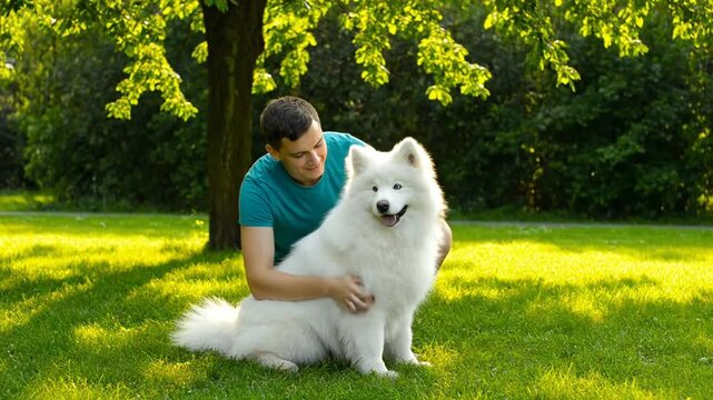 Man pets fluffy dog in park.