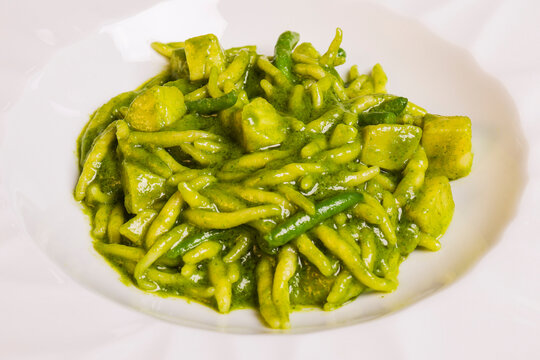Primo piatto tradizionale ligure: trofei al pesto di basilico con patate e fagioli servito in un ristorante elegante 