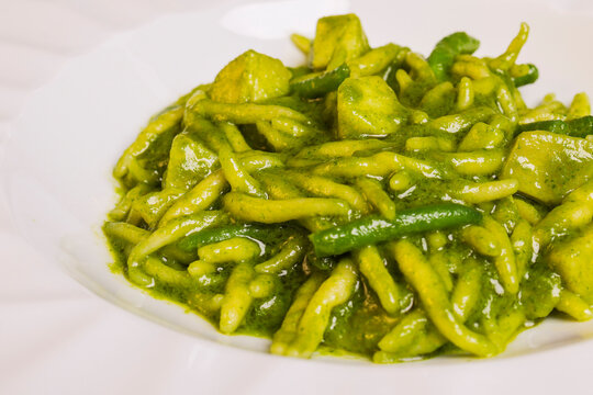 Primo piatto tradizionale ligure: trofei al pesto di basilico con patate e fagioli servito in un ristorante elegante 