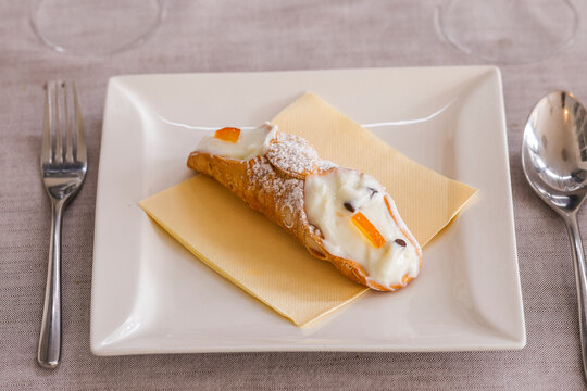 Cannolo, dolce tradizionale siciliano fatto da una sfoglia dolce croccante ripiena di crema di ricotta dolce con gocce di cioccolato fondete e arancia candita