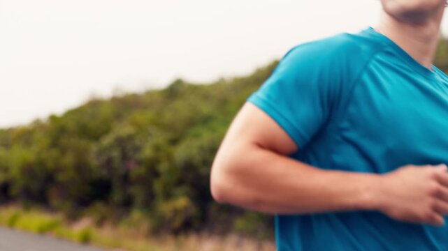 Fitness, man and running with smart watch outdoor for pace timer, endurance and track performance. Mist, athlete and check stopwatch in nature for workout app, exercise challenge and cardio progress