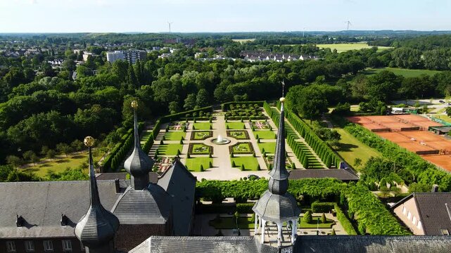 Descending aerial tilt toward Kamp Abbey towers and garden