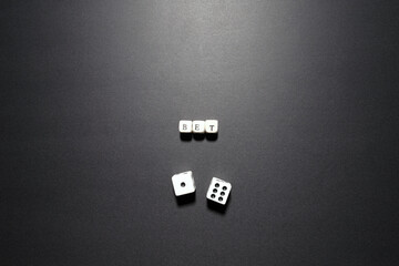 Bet word above dice symbolizing gambling, investment decisions, and taking calculated risks.