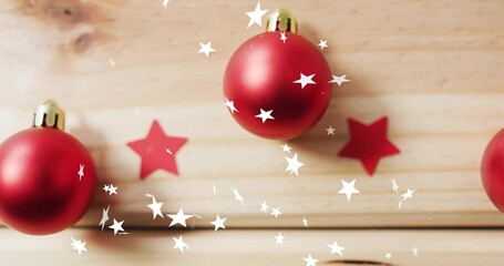 Naklejka premium Displaying three red baubles with gold caps on wooden planks, showing red stars and white bokeh