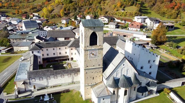 Close tower pullback revealing monastery grounds and mountain setting