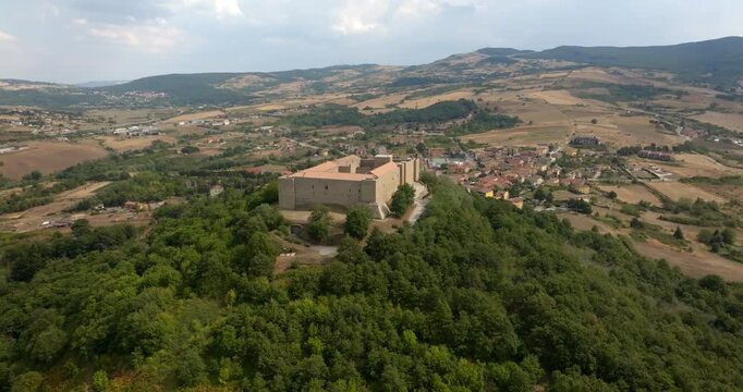 Aerial view of Lagopesole Castle, located in Basilicata, Italy. It is a medieval castle dating back to the time of Frederick II. It sits prominently on a hilltop, overlooking the rolling golden fields